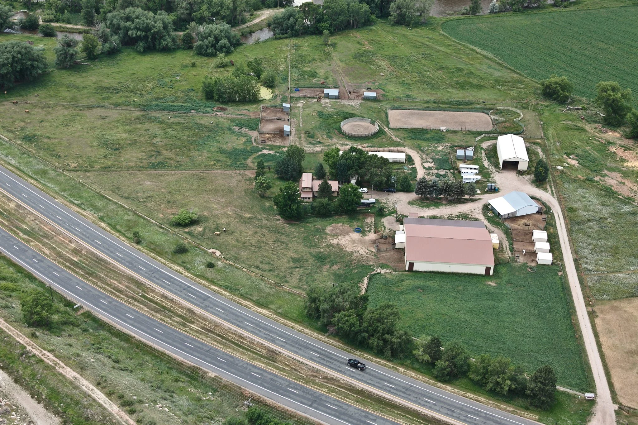 Aerial view of the Canyon Equine facility, arenas, and pastures along the Poudre River